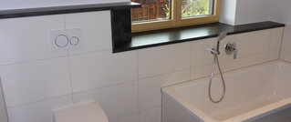 Bad mit einer Ablage und einem Fensterbrett aus schwarzem Naturstein