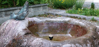 Ein Brunnen aus Naturstein in einem Garten