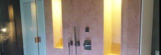 Beleuchtete Duschkabine, die mit Natursteinplatten ausgekleidet ist